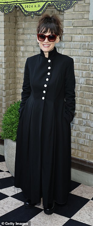 The veteran artist's cape-like look featured a high collar and off-center white buttons along the top half.