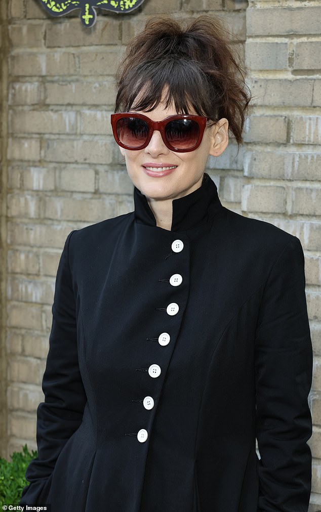 She enhanced the look with shiny black boots and covered her eyes with oversized red-framed sunglasses.