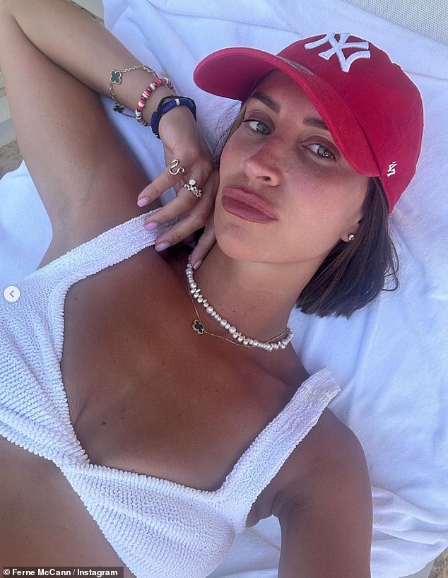 In another snap, Ferne donned a white ribbed bikini and a red baseball cap as she sunbathed on a sun lounger.