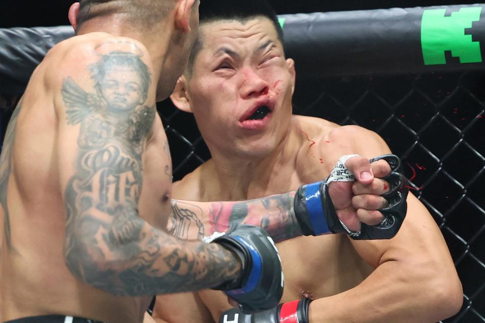 TOPSHOT - China's Li Jingliang (in red) is knocked out by Brazil's Carlos Prates at their Ultimate Fighting Championship (UFC) 305 men's welterweight event at the Perth Arena in Perth on August 18, 2024. (Photo by COLIN MURTY / AFP) / -- IMAGE RESTRICTED TO EDITORIAL USE - STRICTLY NO COMMERCIAL USE -- (Photo by COLIN MURTY/AFP via Getty Images)