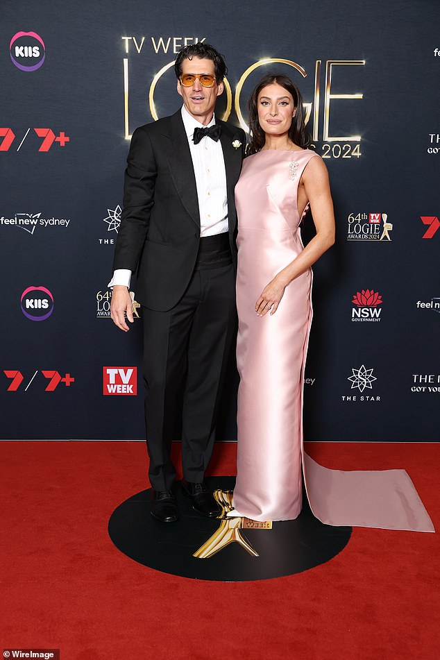 Andy looked dapper in a classic black tuxedo, while Rebecca opted for a chic baby pink dress that featured a high neckline and a pearl brooch.