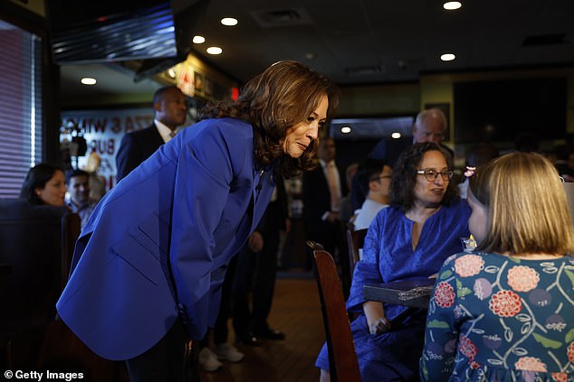 Democratic presidential candidate U.S. Vice President Kamala Harris speaks with a young girl at Primanati Bros restaurant in Moon Township, Pennsylvania.