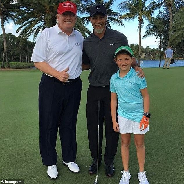 Kai (right) poses with his grandfather Donald and legendary golfer Tiger Woods (center)