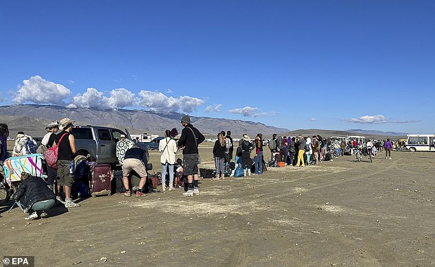 People were urged not to try to walk from the festival, and famous attendees including Chris Rock, actor Austin Butler and DJ Diplo managed to escape. (pictured: a long line of attendees waiting for a bus to leave Burning Man)