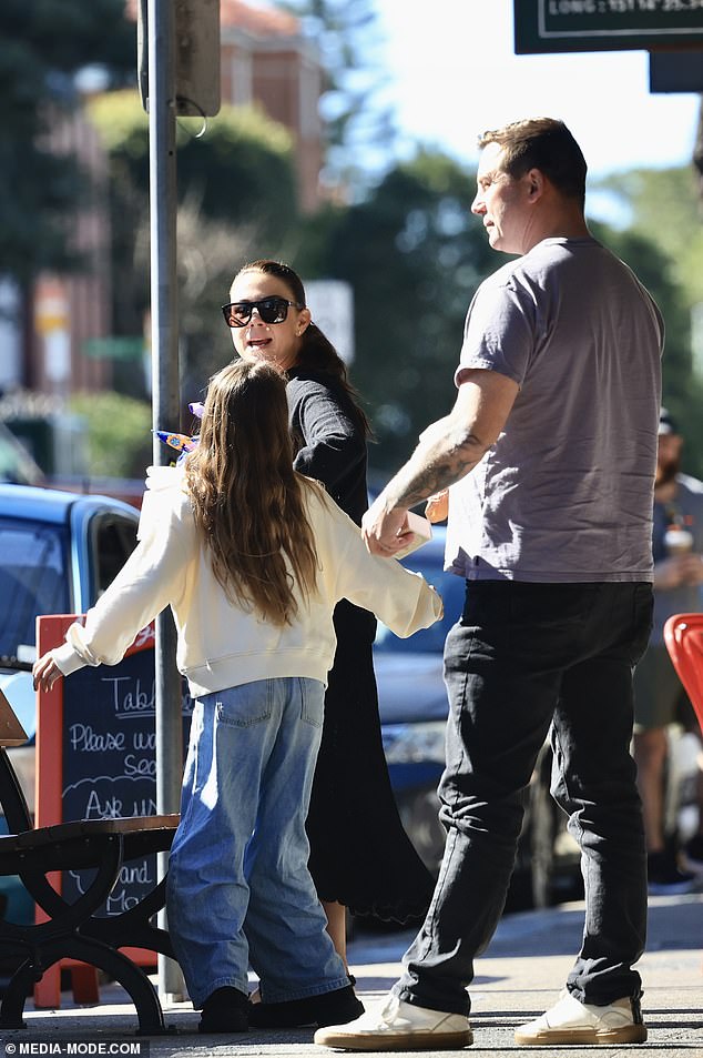 With her brown hair falling in soft waves, the birthday girl looked adorable in a pale yellow sweater and blue jeans.