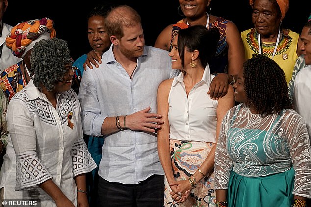 Prince Harry on stage with his wife Meghan for a group photograph after his speech