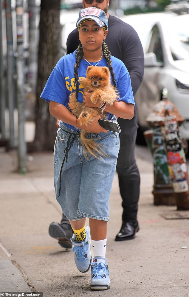 North, 11, was wearing long jean shorts, a blue T-shirt and blue Jordan sneakers as she carried her small family dog.