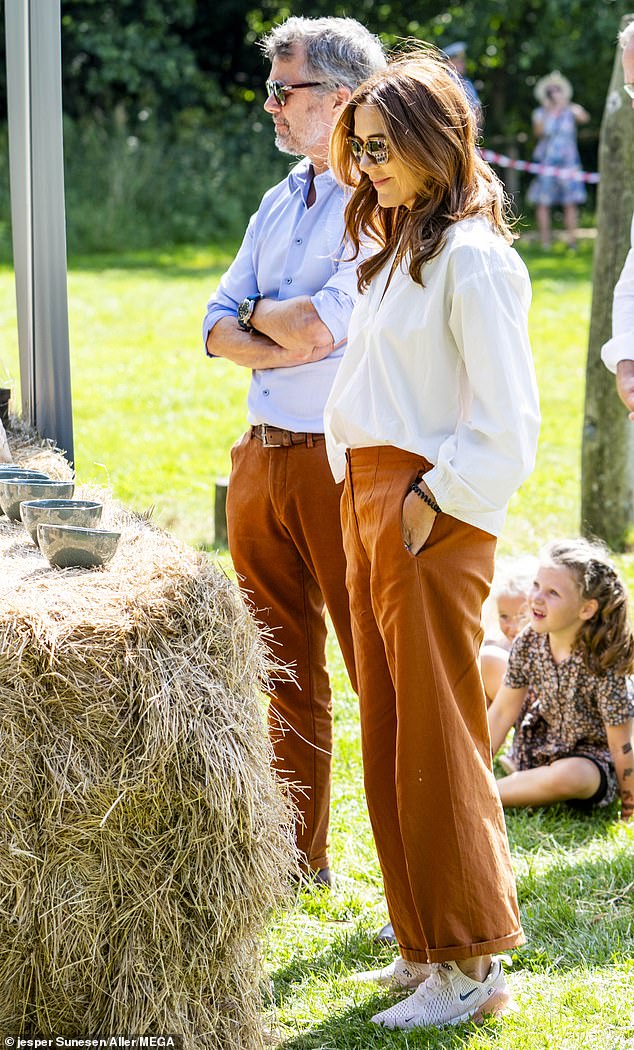 Queen Mary, 52, looked effortlessly chic in a white shirt, rust-coloured trousers and chunky trainers.