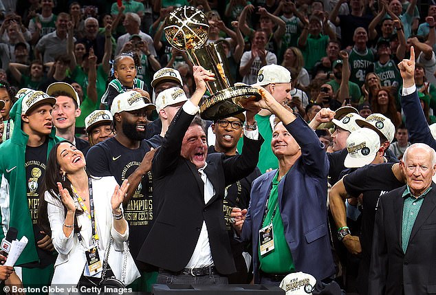 Grousbeck lifts the Larry O'Brien Trophy after the Celtics won their NBA Finals series in June.