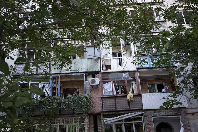 Local residents clean broken glass from their balconies after a Russian shelling in a residential neighborhood in Pokrovsk, Donetsk region, August 20.