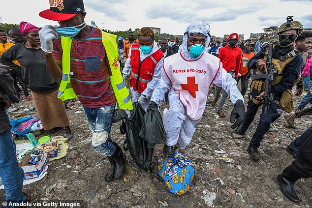 Officials remove bodies found in plastic bags from a garbage dump on July 13