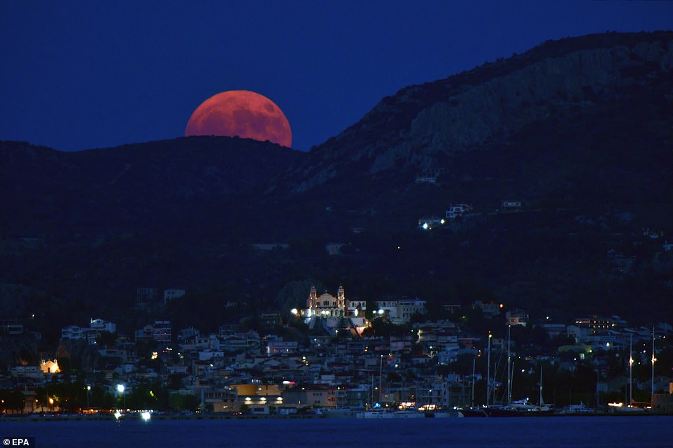 GREECE: The Sturgeon Moon rises over Nafplio, Peloponnese, Greece. The term supermoon was coined by astrologer Richard Nolle in 1979