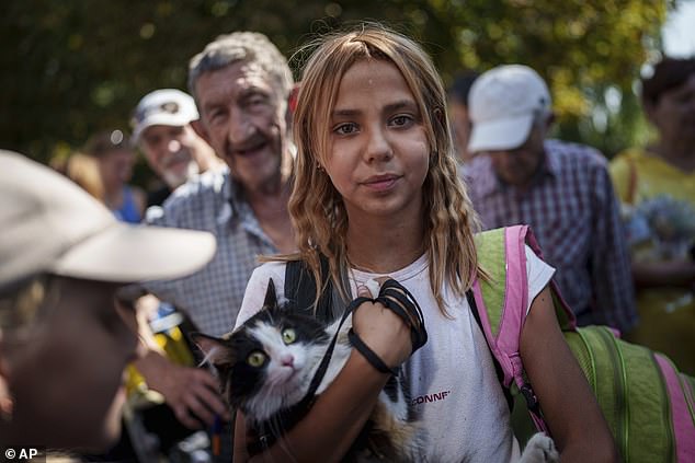 Russia's rapid advance has already forced tens of thousands of Ukrainians to flee their homes (pictured: a young woman queues to board the evacuation train in Pokrovsk, Donetsk region)