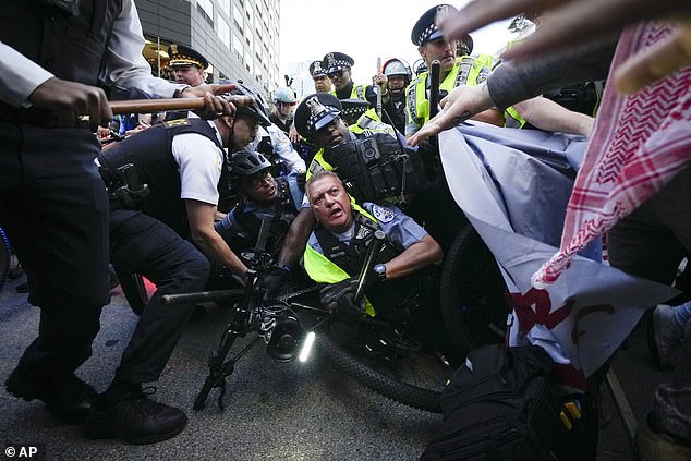 Protesters pushed police onto the sidewalk as chaos escalated Tuesday night.