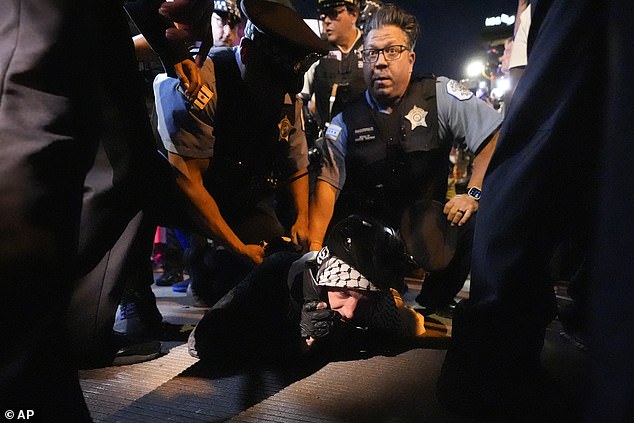 A protester is detained by police near the Israeli Consulate during the Democratic National Convention on Tuesday, Aug. 20, 2024, in Chicago.