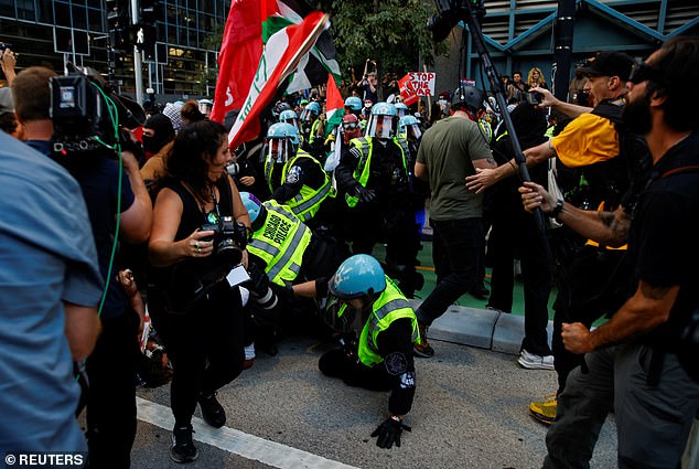 The media was caught in the middle of the clash between protesters and police, a member of the press can be seen running upstairs while a law enforcement officer falls to the ground.