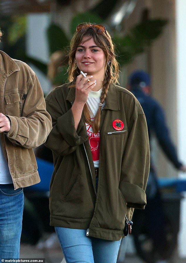 The teenager styled her fringe locks into two loose braids and appeared to be in high spirits as she smiled and laughed with her friends.