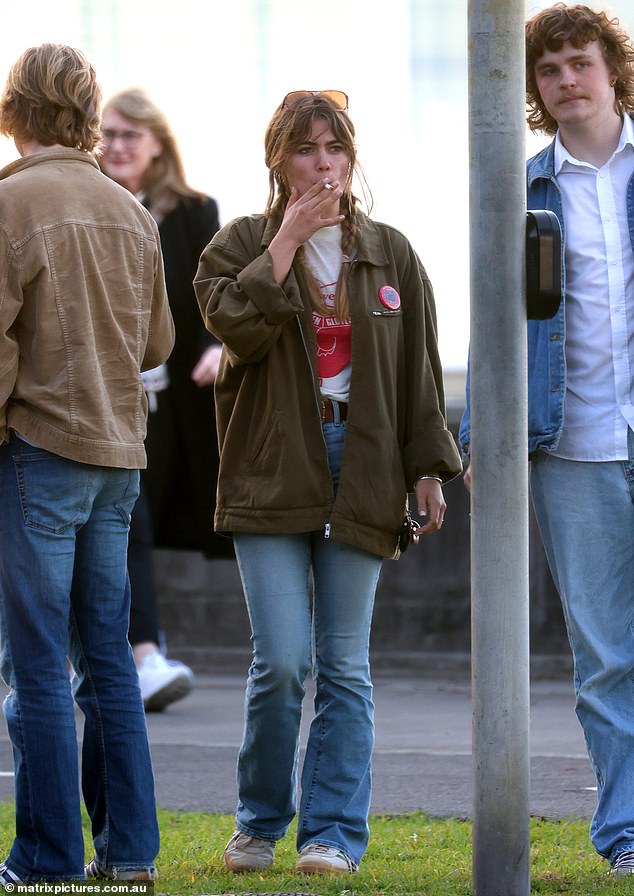 He smoked a cigarette as he gathered outside the venue with his friends before enjoying a bite to eat.