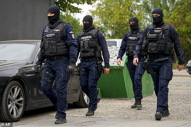 Gendarmes wearing balaclavas walk past the residence of internet influencer Andrew Tate during an early morning police raid, outside Bucharest, Romania, Wednesday, August 21, 2024.