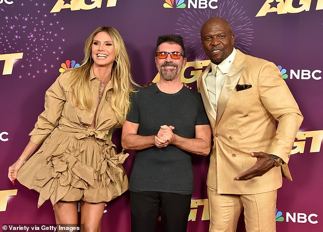 She completed her comfortable, dark outfit with a pair of striking red sunglasses; pictured with Heidi and presenter Terry Crews.