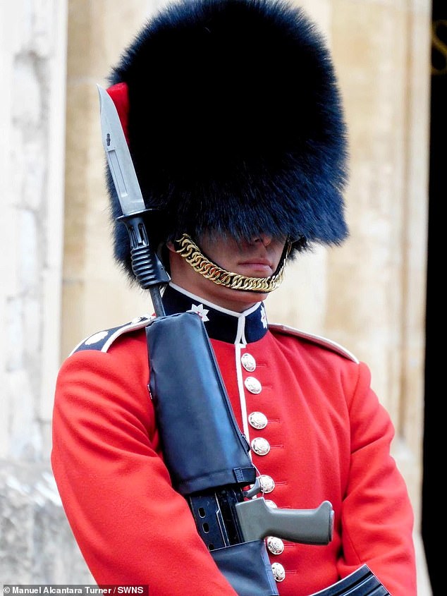 The soldier can be seen in the snapshot wearing his full scarlet Royal Guard uniform, complete with bearskin cap.