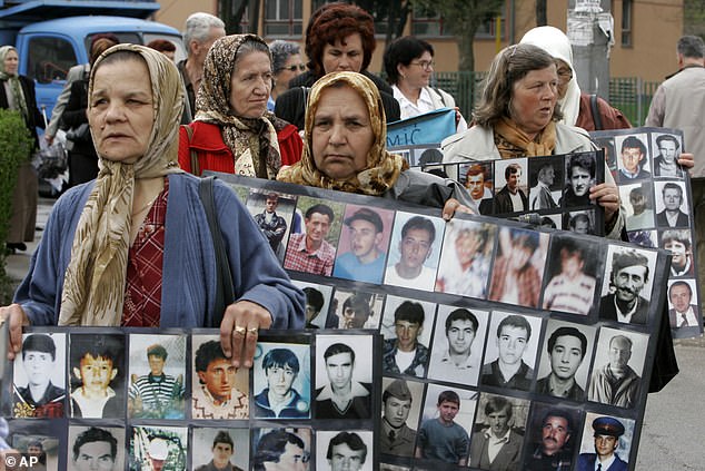 Karadzic is behind some of the most heinous war crimes since World War II. Pictured: Bosnian Muslim women and survivors of the Srebrenica massacre hold signs with photos of missing men after the fall of Srebrenica, during a peaceful protest in Tuzla, 70 km (43 miles) north of Sarajevo, Tuesday April 11, 2006