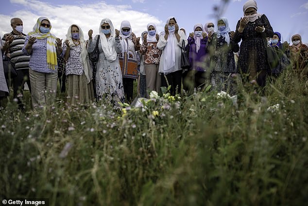 Bosnian Muslim women pray as relatives of victims of the Srebrenica genocide visit the sites where their loved ones were mass executed in 1995, on July 13, 2020 in Brnjevo, near Srebrenica, Bosnia and Herzegovina