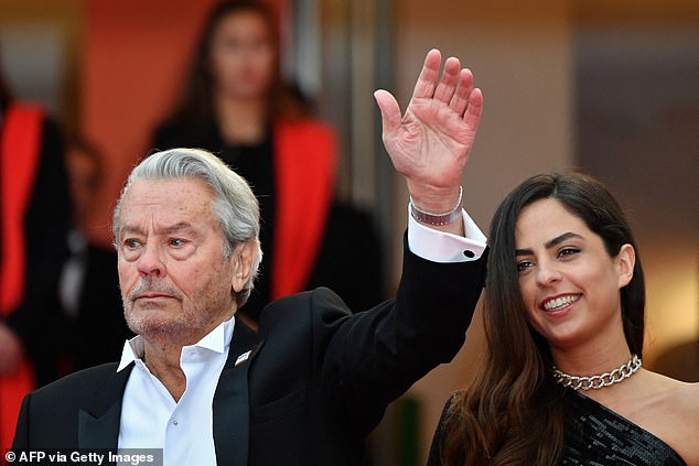 French actor Alain Delon waves as he arrives with his daughter Anouchka Delon to receive the honorary Palme d'Or at the 72nd Cannes Film Festival in Cannes, southern France, on May 19, 2019.