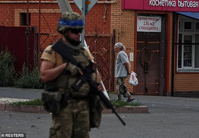 A Ukrainian soldier patrols an area in the town of Sudzha, controlled by the Ukrainian army, in the Kursk region, Russia