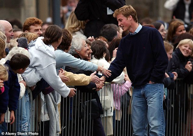 Prince William shakes hands with people in the crowd outside the University of St Andrews