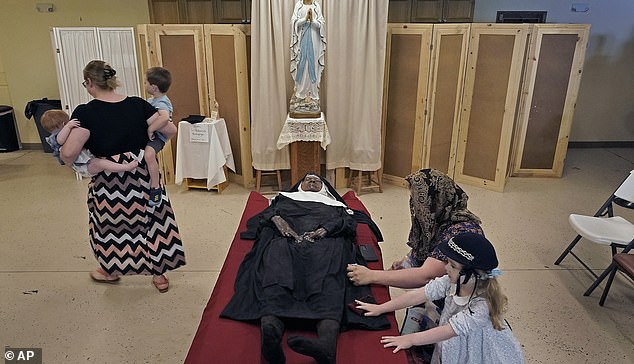 Pictured: People pray over the body of Sister Wilhelmina Lancaster at the Benedictine Abbey of Mary, Queen of the Apostles, Sunday, May 28, 2023.