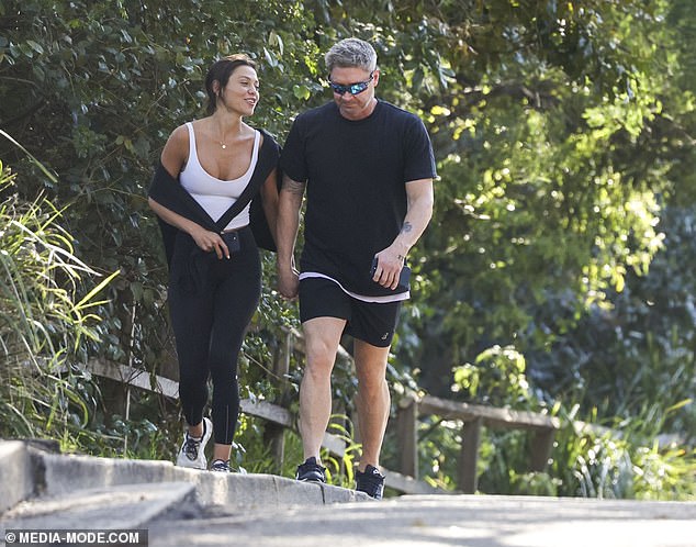 Arabella showed off her figure in black sports leggings and a tight white T-shirt as she laughed while chatting to her boyfriend.