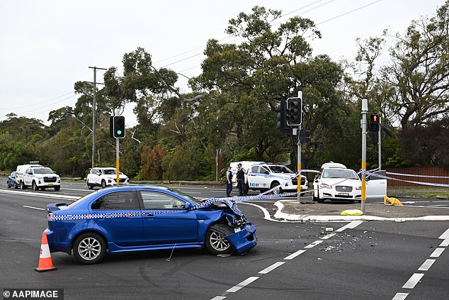 Police are investigating the incident in which several passengers were taken to hospital with stab wounds (pictured: the wrecked blue Mitsubishi sedan).