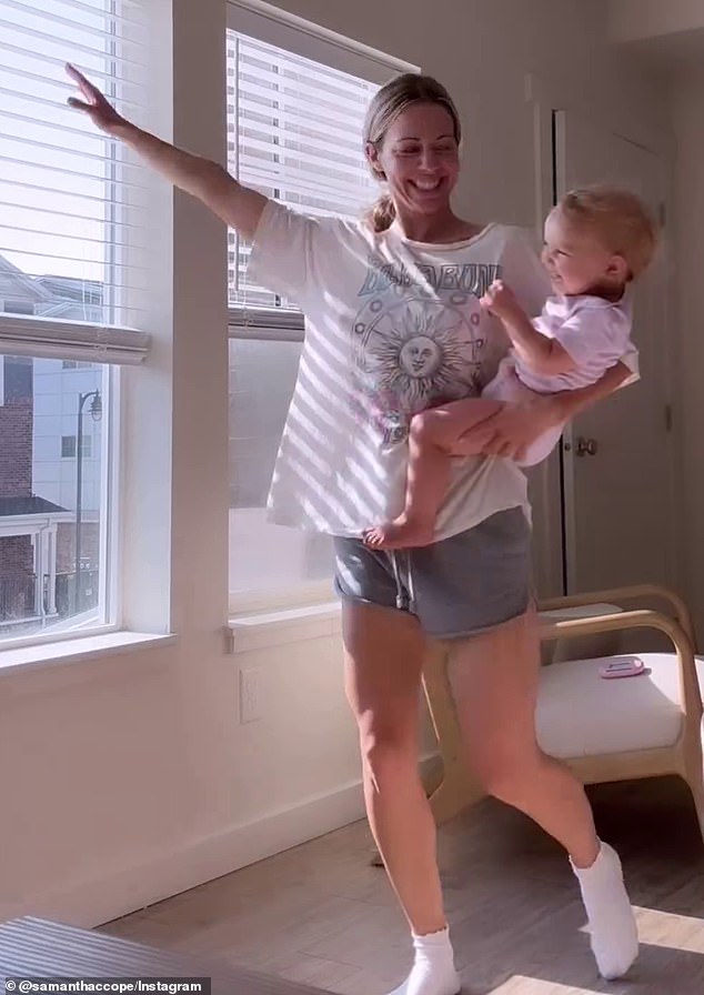 The video then shows Samantha showing a big smile on her face as she spins around with her daughter in her arms inside a spacious bedroom.