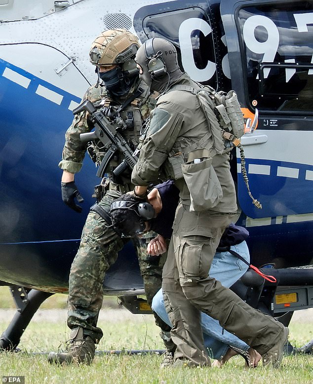 The suspect was seen being dragged to his appearance at the Federal Supreme Court (BGH) in Karlsruhe, Germany, today by federal police officers, who took him to the southwestern court by helicopter.