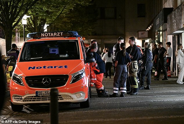 An ambulance and police stand on August 24, 2024 near the site where at least three people were killed and several others injured.