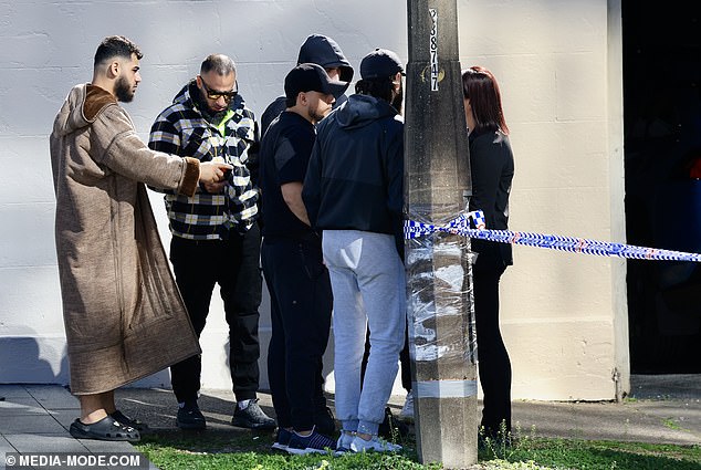 Pictured: Friends and family comfort each other following the shooting.