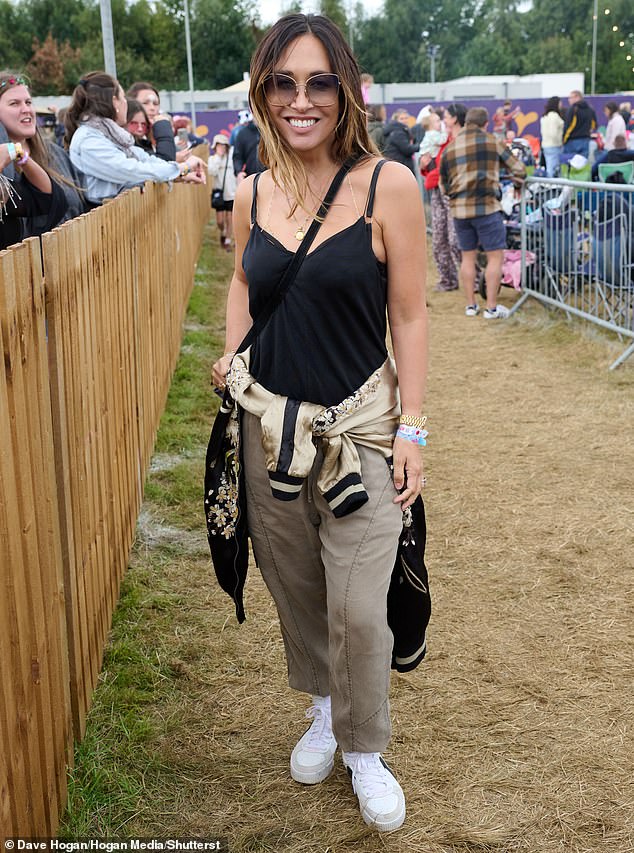 For the third day of the music event, Myleene wore a black vest and khaki pants and braved the mud in bright white sneakers.