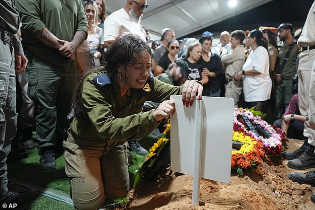 The sister of Petty Officer 1st Class David Moshe Ben Shitrit, who was killed in a Hezbollah attack, cries during his funeral at the Mount Herzl military cemetery in Jerusalem, Sunday, Aug. 25, 2024.