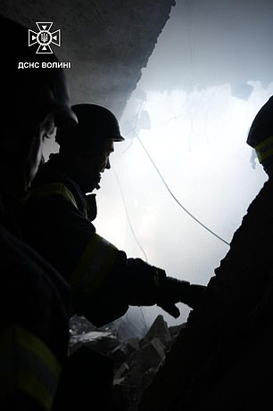 Rescue workers inside a building in Lutsk after it was hit by a Russian drone strike