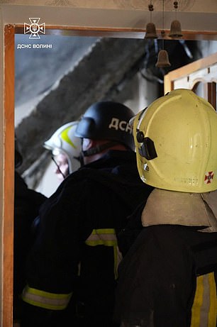 Rescue workers inside a building in Lutsk after it was hit by a Russian drone strike