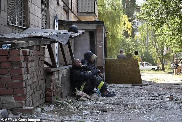 Ukrainian rescuers take a break during a search and rescue operation in the rubble of a destroyed hotel after an attack in the city of Kramatorsk, Donetsk region, on Sunday.