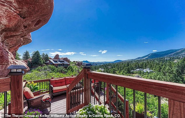 'Head upstairs to the landing where you'll find an entrance to the home's featured outdoor deck and viewing space,' the listing states, highlighting the stunning views of the Rocky Mountains.