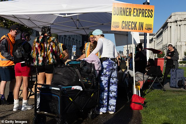 Festival-goers check in for buses heading to Burning Man at Civic Center Plaza on Sunday