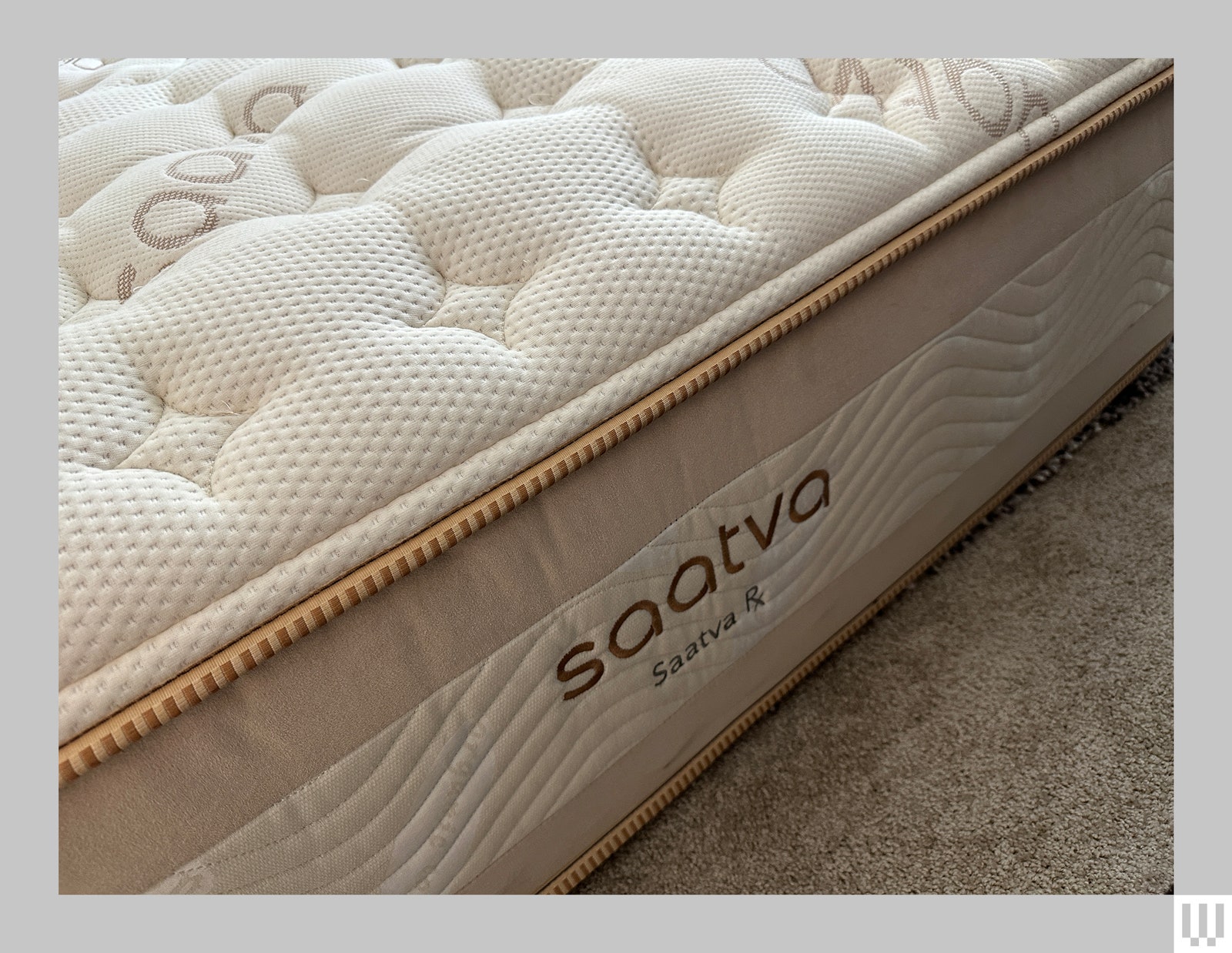 Side view of a thick mattress with a white top and beige trim.