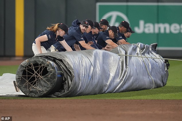 Ground crew members unroll tarp in Minneapolis at the start of the storm.