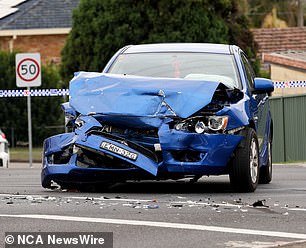 A blue sedan with the front half completely destroyed.