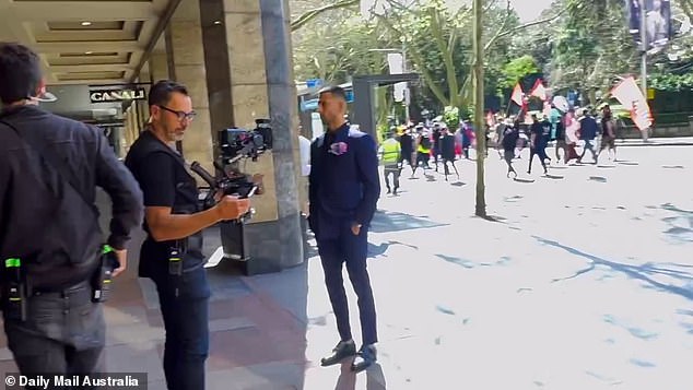 The Brisbane-based model was kept busy chatting to the film crew as they were forced to wait for protesters to cross the road.