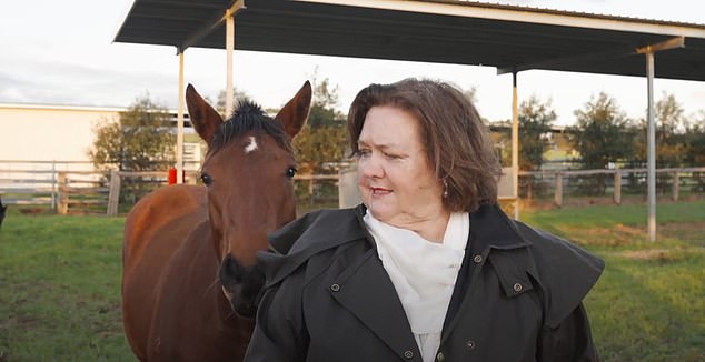 Despite trying to bravely continue his speech, the horse refused to be ignored as he nuzzled Ms Rinehart's back.