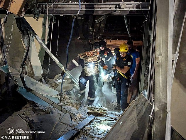 Rescuers carry a victim from the site of a Russian missile attack in Kryvyi Rih